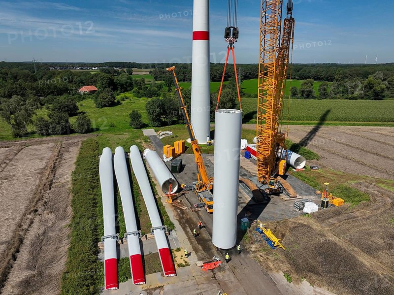 Dorsten, North Rhine-Westphalia, Germany, construction of a wind turbine, the first wind turbine of the Grosse Heide wind farm. The rotor blades are ready for assembly. A large mobile crane places the tower elements, the rings, on top of each other. This wind turbine will have a rated output of 5, 500 kW