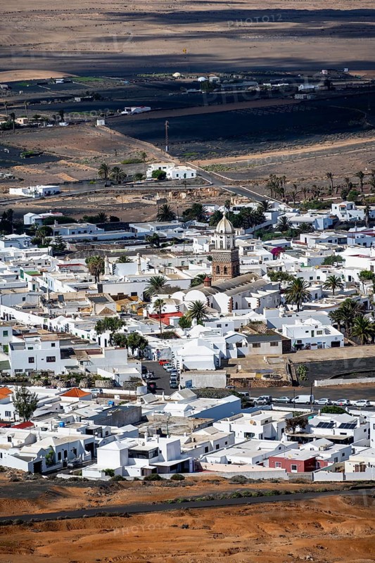 View of town, white houses of Teguise with church tower in dry volcanic landscape, Lanzarote, Canary Islands, Spain