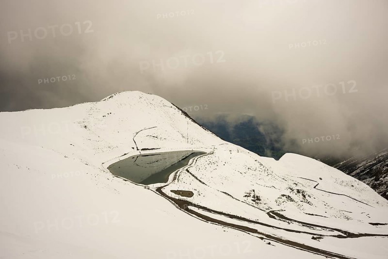 After snowfall in May: Riezler Alpsee, an artificial lake, snow pond, feeds the snow cannons that completely cover the slopes of the Fellhorn and Kanzelwand cable cars with snow, Allgäu Alps, Vorarlberg, Austria