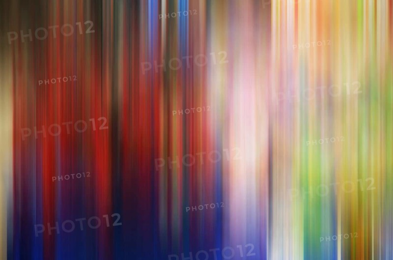 Vibrant, vertical streaks blend seamlessly in this abstract photograph, presenting a splash of colors ranging from deep blues to fiery reds and mild greens