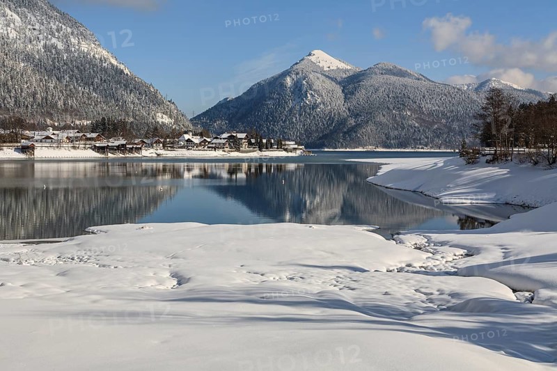 Mountains reflected in lake, village, houses, winter, snow, sunny, Walchensee, behind Jochberg, Bavaria, Germany