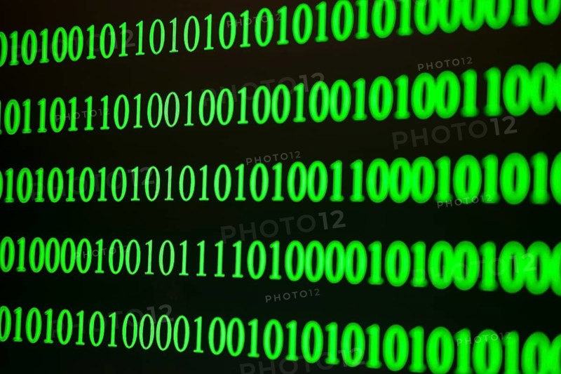 Green binary code in ordered rows on a dark background