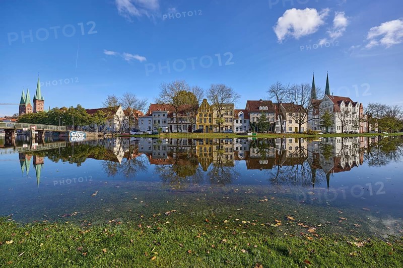 River Trave at high water, old town with historic buildings, blue sky with fair weather clouds, Hanseatic city of Lübeck, Schleswig-Holstein, Germany