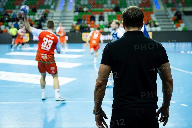 View form the behind on head coach and substitutions bench with handball match in background in Lubin, Poland