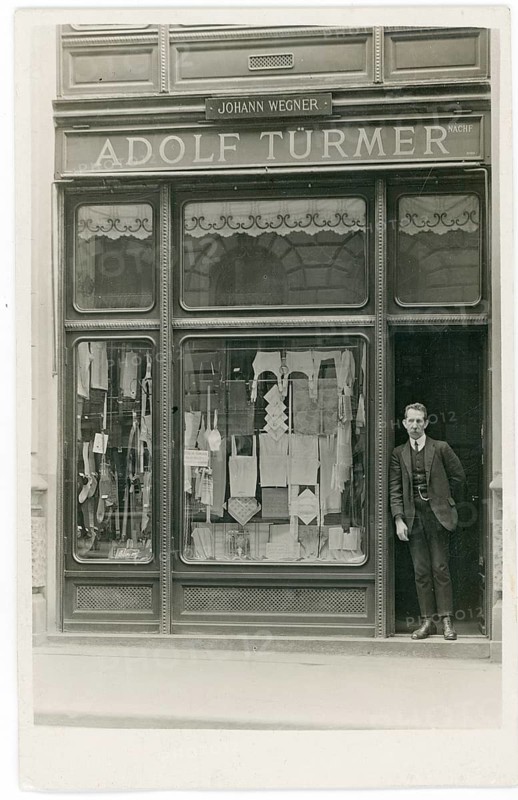Vienna, shop, underwear, fashion, Adolf Türmer, Johann Wegner, black and white photo of a man standing in a suit in front of a shop with a shop window, around 1920