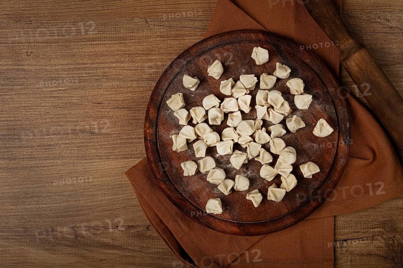 Traditional Turkish dumplings, raw, on a cutting board, top view, no people