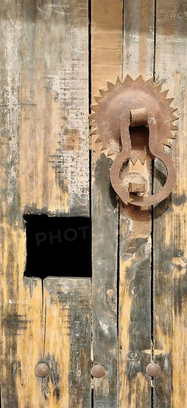 Rustic wooden door with a metal knocker in a traditional design, Morocco