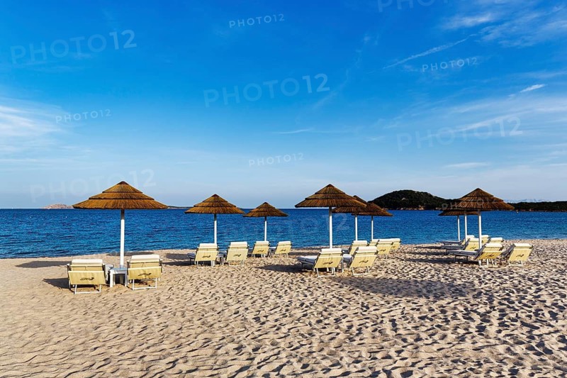 Straw umbrellas, empty sunbeds overlooking the Mediterranean Sea, beach club, Liscia Ruja, sandy beach on Costa Smeralda, Cirrus, Arzachena, Sardinia, Italy