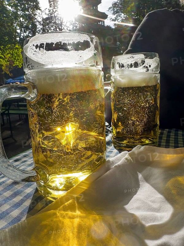 Full beer mugs on a set beer garden table in front of the Chinese Tower, English Garden, Munich, Bavaria, Germany