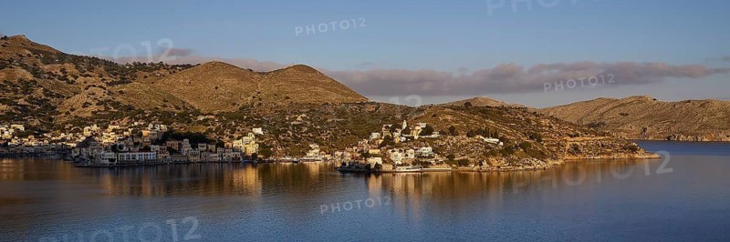 Island view with rolling hills and calm water, blue sky with scattered clouds, Symi Town, Symi, Dodecanese, Greek Islands, Greece