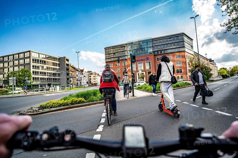 Cycling in the city, inner-city road, cyclist, e-scooter at pavement traffic light, no cycle path, two-lane traffic in both directions, cyclist perspective, Essen, North Rhine-Westphalia, Germany
