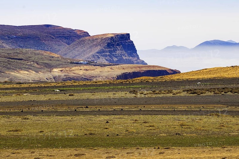Vast volcanic landscape with flat plains, plateaus and a clear sky in the background, Lanzarote, Canary Islands, Spain