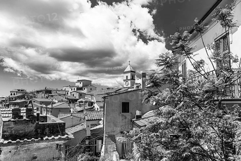 Above the roofs of Capoliveri, behind the church tower of San Michele, black and white photograph, Capoliveri, Elba Island, Tuscan Archipelago National Park, Tuscany, Italy