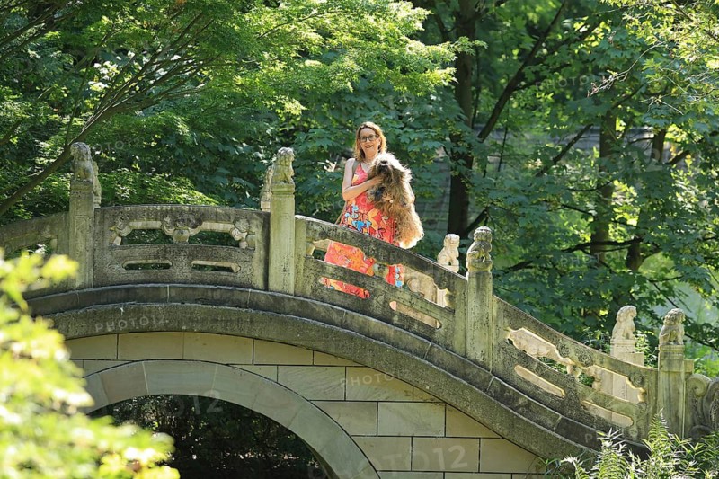 Woman with dog standing on a bridge, Chinese Garden at Duisburg Zoo, Duisburg, North Rhine-Westphalia, Germany