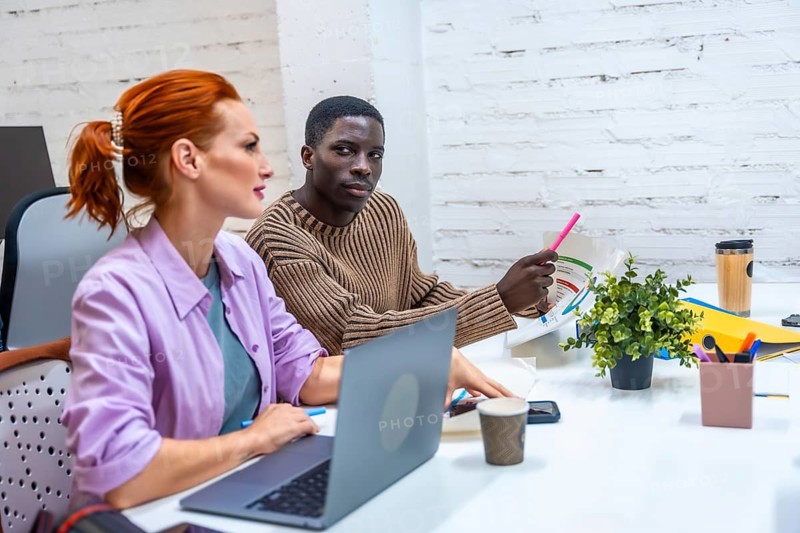 Multi-ethnic coworkers in a meeting room discussing and working together