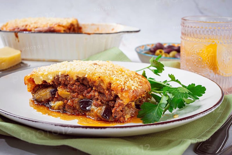 Moussaka served with olives, in a bright kitchen setting, homemade, no people