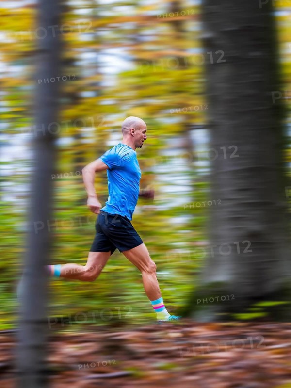 Man in a training session, trail running outdoors, healthy lifestyle, colorful autumn forest, Swabian forest, valley Remstal, Germany