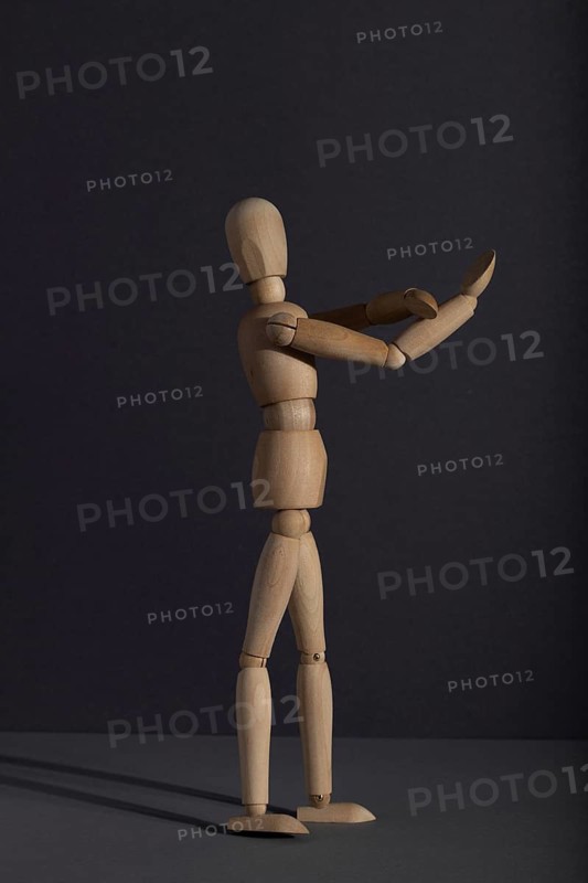Wooden mannequin shows obscene gesture fuck off with hands on gray background. protest, riot, agression, contempt concept. copy space, hard light