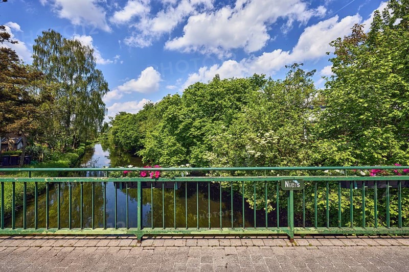 Niers river, car bridge and footbridge, metal railing, riverbank, flower boxes, trees, blue sky, cumulus clouds, Achter de Stadt, Wachtendonk, Kleve district, North Rhine-Westphalia, Germany