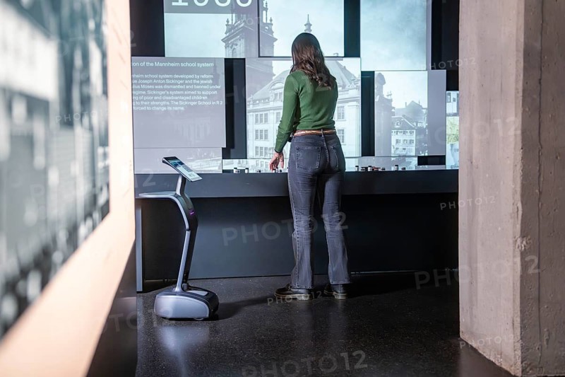 Woman looking at historical exhibits on interactive displays, museum robot Robolutions, Marchivum, Mannheim, Germany