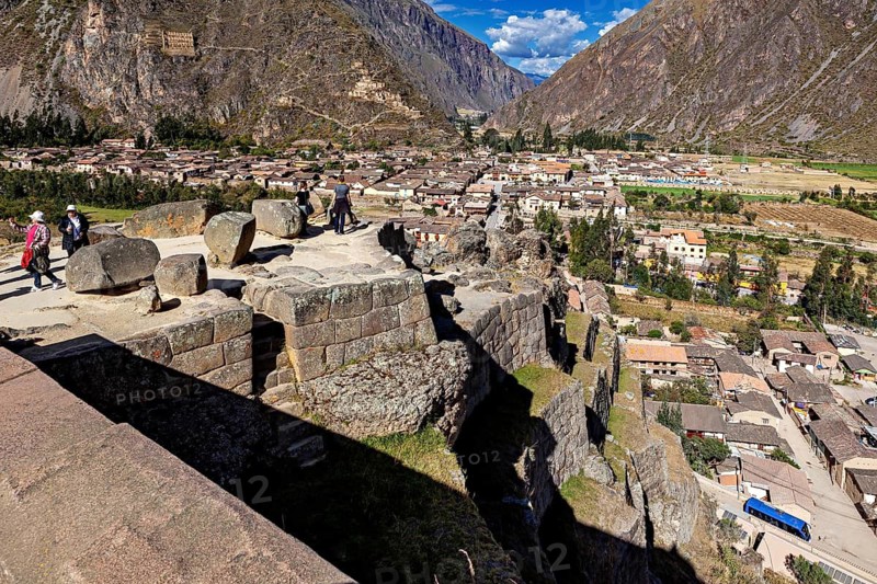 Historic stone platform overlooking a city and surrounding mountains, The Inca ruins of Ollantaytambo in the Andes of Peru