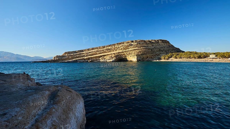 Neolithic caves, former hippie paradise, rocky landscape by the sea under clear blue sky with calm water, Matala, south coast, Crete, Greek islands, Greece