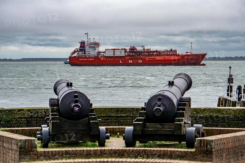 The LNG tanker Coral Furcata, in the Westerschelde, has left the harbour of Antwerp and is heading for the UK, historic cannons at the Oranjedijk, in Vlissingen, Zeeland, Netherlands