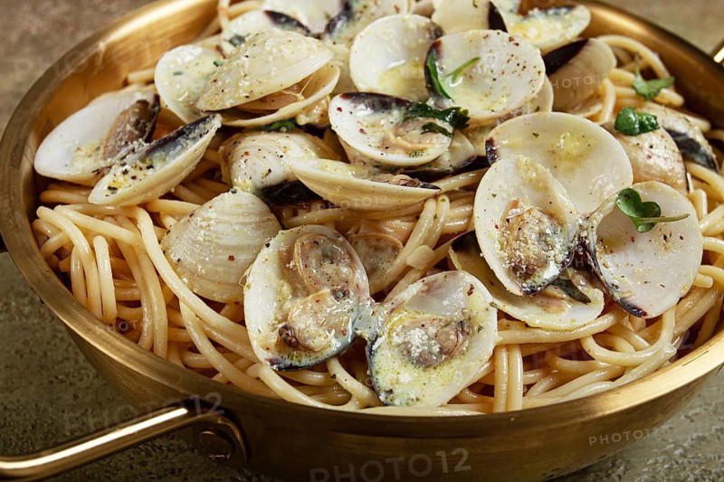 Spaghetti with vongole clams, in cream sauce, carbonara, in a brass pan, homemade, top view, no people