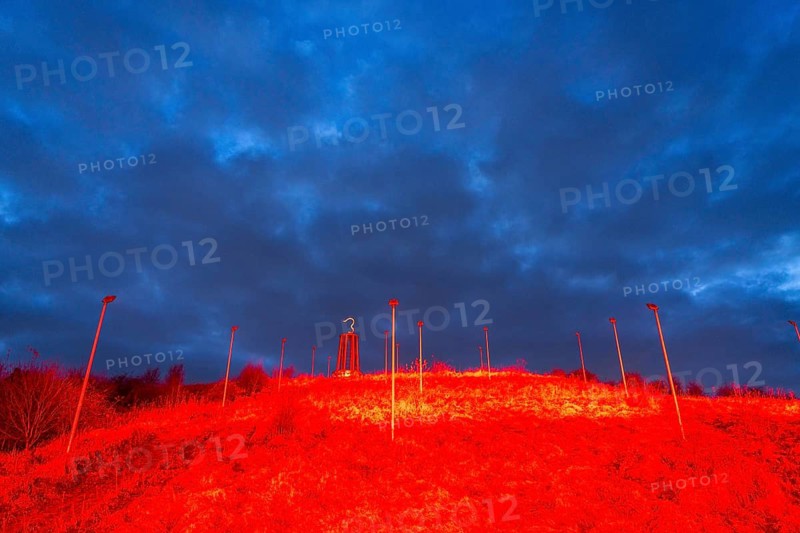 Rheinpreussen spoil tip in Mörs, spoil tip symbol Das Geleucht, light installation red illuminated slope, tower in the shape of a miner's lamp, dramatic sky, North Rhine-Westphalia, Germany