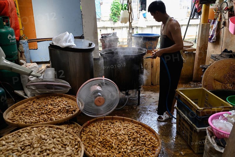 Bangkok, Thailand. February 19th 2025. AbThai worker washes peanuts in a workshop at the Khlong Toei Market, Bangkok, Thailand, Asia