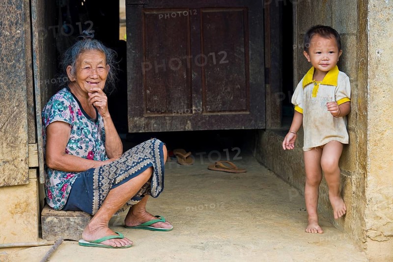 Laotian elderly woman and young boy in a Hmong village in a very simple wooden house, wooden cabin, Pha Yung, Muang Ngoi on the Nam Ou River, Phongsali Province, Laos