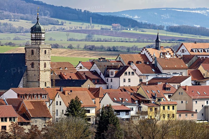 City view with historic tower, red roofs and rolling hills in the background, the skyline of Geisa in the Rhön in Thuringia