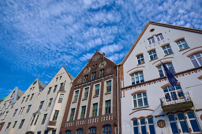 Row of historic Hanseatic houses with striking facades under a clear blue sky, Bryggen, Bergen, Vestland, Norway