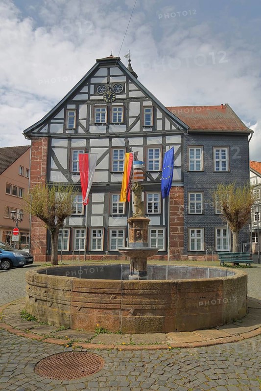 Town hall with Hessian state flag, German national flag and EU flag, fountain, half-timbered house, Treysa, Schwalmstadt, Hesse, Germany