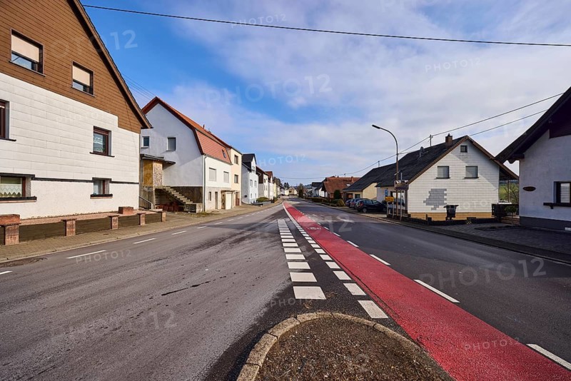 Residential building, trees, cycle path, roadway, blue sky with cumulus clouds, intersection of Saarbrücker Straße and Ottweilerstraße, Illingen, district of Neunkirchen, Saarland, Germany
