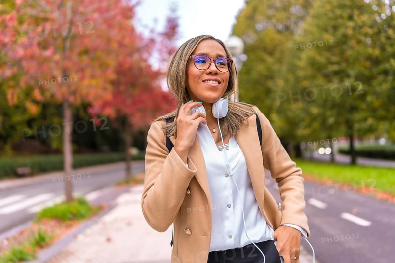 Frontal portrait of a latin cool businesswoman with headphones in the city