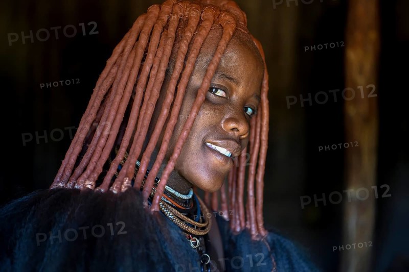 Young Himba woman in her hut, Ohandungu, Kunene region, Kaokoveld, Namibia