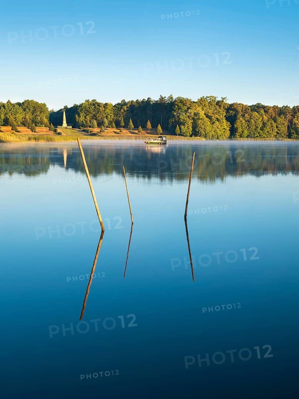 Morning atmosphere at Lake Grienerick, fish traps in front, the obelisk behind, Rheinsberg, Brandenburg, Germany