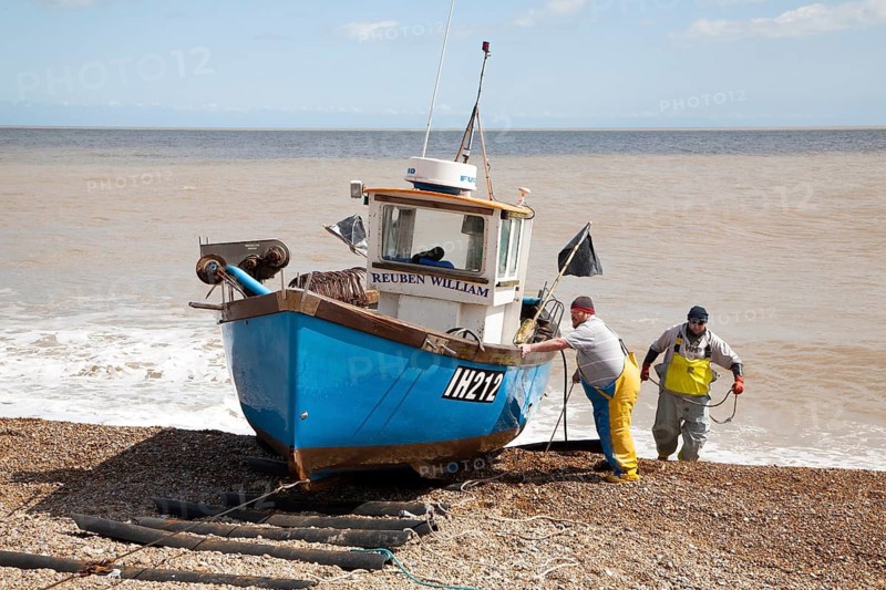 Small inshore fishing boat landing on the beach after six hours at sea with a catch of cod and skate, Aldeburgh, Suffolk, England, United Kingdom