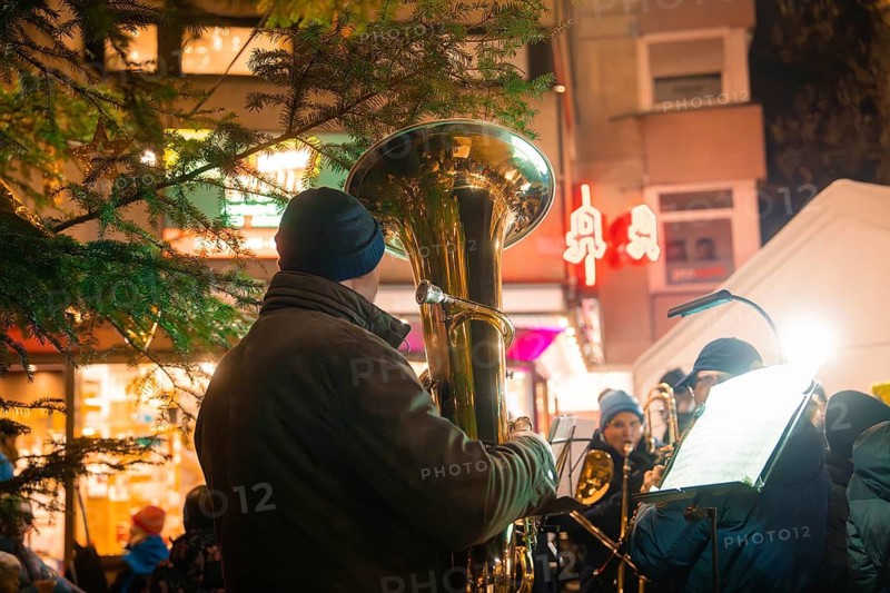 Musician with tuba plays at a Christmas market with night illumination, Lichternacht Fest, Nagold, Black Forest, Germany
