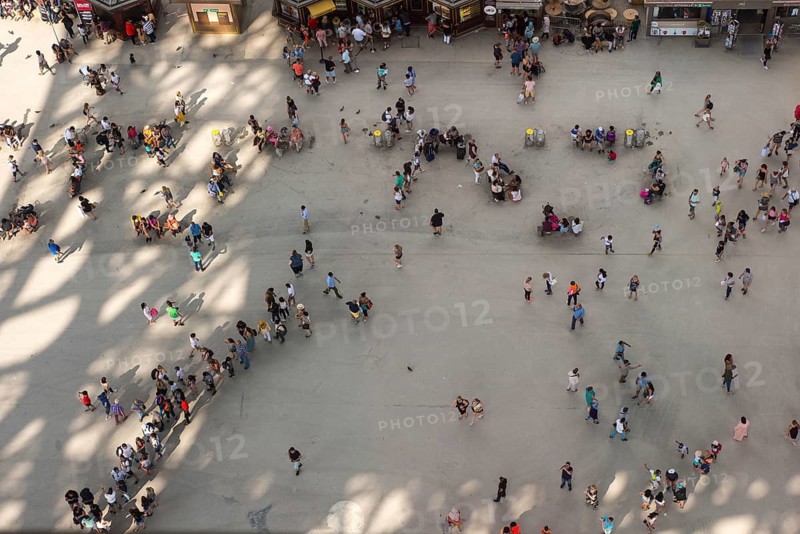 People, top view of a crowd, tourists queuing and walking, standing on square under Eiffel Tower, street pigeons or city pigeons, shadow cast by Eiffel Tower on a sunny day, Paris, France