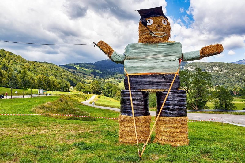 Funny straw puppet made of straw bales, figure, man smoking a pipe, Savoie, Auvergne-Rhone-Alpes, France