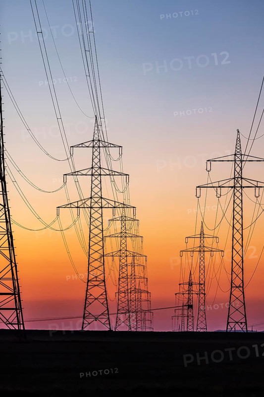 High-voltage pylons, overhead power lines at sunset. Schwieberdingen, Baden-Württemberg, Germany