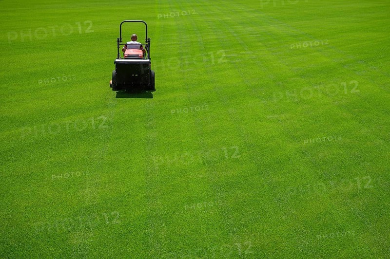 Mowing grass at the football stadium in Lubin, Poland