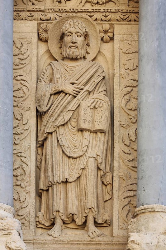 Saint Baratholomew stone sculpture with book and halo, relief, stone carving, handicraft, St-Trophime church, Arles, Provence, Ste-Anne, Place de la République, Arles, Bouches-du-Rhône, Camargue, Provence, France