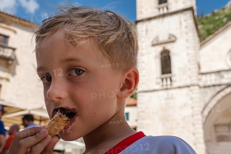 Young boy eating ice cream during summer day