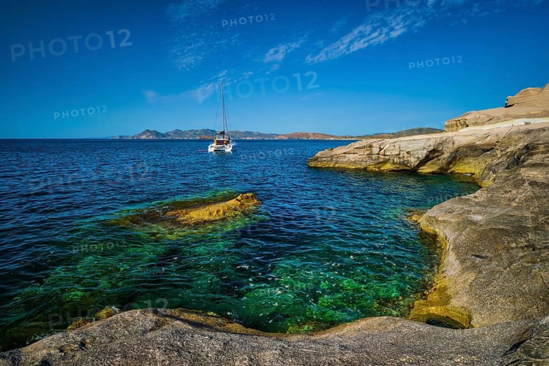 Yacht boat in Aegean sea at white rocks of Sarakiniko Beach, Milos island, Greece