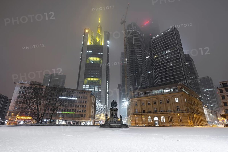 Snow lies on the Rossmarkt in Frankfurt am Main. Most of the office lights in the skyscrapers of the banking skyline are dark. Frankfurt am Main, Hesse, Germany