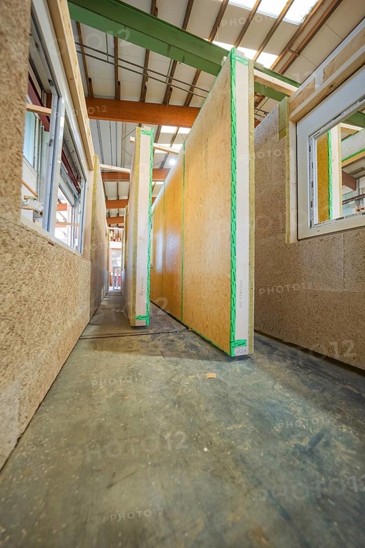 A narrow corridor between tall wooden panels in a new building on a construction site, façade construction in carpentry, climate-friendly construction, Nagold, Germany