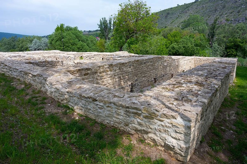 Old stone walls surrounded by lush greenery in a hilly landscape, Tatar bathhouse, Feredeu bath, Old Orhei, Orheiul Vechi, archaeological site, historical-landscape reserve, Orhei district, Republic of Moldova, Moldova